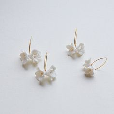 Each earring is exquisitely made by hand, featuring two delicate white clay flowers adorned with freshwater pearls. Skillfully handcrafted, these flower bridal earrings are the perfect complement to our signature porcelain headpieces.  These earrings are extremely lightweight. They are very elegant in their simplicity and have a very versatile design that would match many different wedding dress styles. ITEM SPECIFICATIONS ♥Flower Size about : 0.4*0.4in  0.6*0.6in ♥The earrings are available in Elegant White Flower Hoop Earrings, Delicate Flower Hoop Earrings For Weddings, Delicate White Hoop Earrings For Wedding, Adjustable White Jewelry With Flower Decoration, White Hoop Earrings For Celebration, Delicate White Hoop Earrings With Ear Wire, Delicate White Jewelry For Bridesmaid Gift, Delicate Handmade White Hoop Earrings, Flower Shaped Hoop Earrings With Ear Wire For Wedding