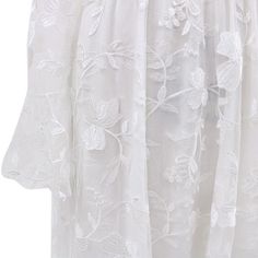 a white blouse with flowers and leaves on it