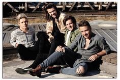 four men sitting on the ground posing for a photo