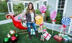 a woman standing in front of some candy canes and christmas presents on the lawn