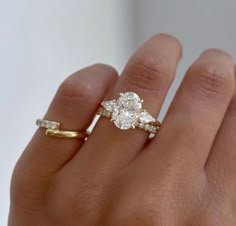 a woman's hand with a diamond ring on top of her finger and two diamonds in the middle