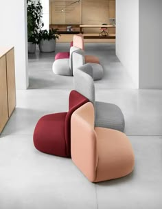 several different colored chairs sitting in a room next to each other on concrete flooring