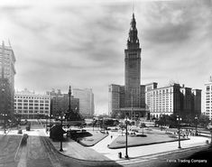 an old black and white photo of a clock tower in the middle of a city