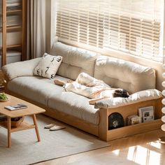 a living room with a couch, coffee table and bookshelf in the corner