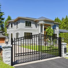 a gated driveway leading to a large house