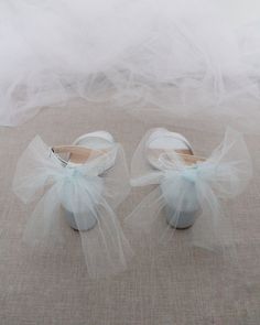 a pair of white shoes sitting on top of a floor next to a veiled wall