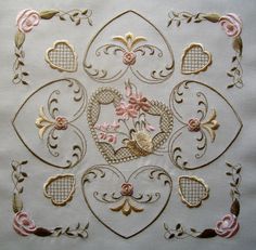 a white table cloth with pink flowers and hearts in the center on top of it