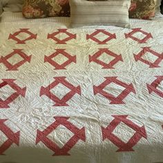 a bed with a red and white quilt on it