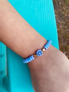 a child's arm with a bracelet that has an elephant and star on it