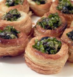 small pastries with broccoli and other toppings arranged on a white plate