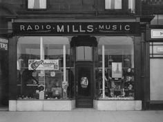 an old black and white photo of a radio mills music store front with its windows open