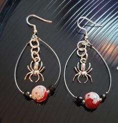 Spooky silver spiders protect their blood-spattered egg sacks!  Fun and festive for Spooky Season! Ear wires are sterling silver. All items come in one-of-a-kind gift boxes! Themed Pierced Earrings As A Gift, Themed Earrings For Pierced Ears As Gift, Whimsical Silver Earrings For Gift, Christmas Novelty Silver Jewelry, Themed Gift Earrings, Spooky Nickel-free Jewelry For Party, Handmade Halloween Earrings Gift, Spooky Nickel-free Party Jewelry, Handmade Jewelry For Halloween Party