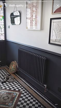 a black and white tiled floor with a radiator in the corner next to it