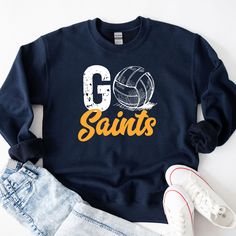 a sweatshirt with the words go saints and a volleyball ball on it, next to ripped jeans