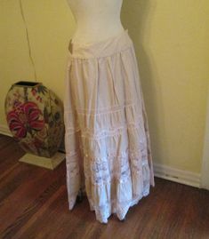 Vintage Bebe maxi skirt lace trim oatmeal color and gorgeous. This skirt is elegant with a boho style.  The waist is very flattering. It has inner buttons to wrap the skirt around. The skirt has wonderful embroidery with silk (or satin)ribbons and lace. You can tie the silk sash in the front, back or wrap around. It's made of a sturdy cotton and would look great with sandals or boots, can be worn with a tee shirt, a delicate blouse or short jacket (or any other way you think). Works for casual and dressy occasions. This skirt is suitable to be worn summer or winter. In excellent condition. It is marked small but please see measurements below, it could fit a medium poss a large. You also can move the buttons to tighten or loosen it. Measurements: Waist. 30" Hips. 42" full Length. 41" Thanks Peasant Skirt, Articles Of Clothing, Satin Ribbons, Oatmeal Color, Womens Skirts, Pretty Clothes, Short Jacket, Embroidered Lace, Satin Ribbon