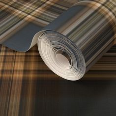 a close up of a roll of paper on the ground with a plaid pattern in the background