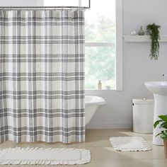 a bathroom with a toilet, sink and shower curtain