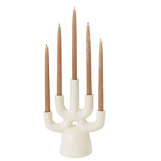 a white candle holder with five candles in it