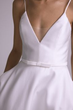 the back of a woman's white wedding dress with an open v - neckline