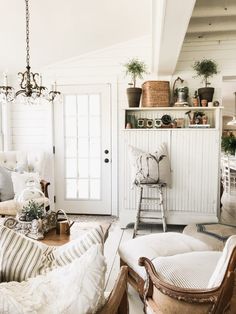 a living room filled with lots of furniture next to a white door and window sill