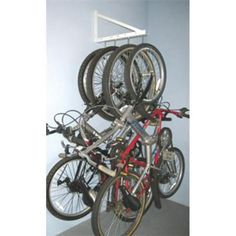 there is a rack with many bikes on it and one bike has wheels attached to the wall