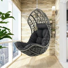 a hanging chair in the middle of a room with wood flooring and brick walls