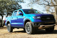 a blue truck is parked in the dirt