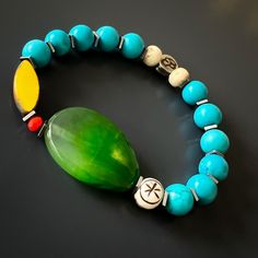 The Green Agate Summer Vibe Bracelet is a stunning accessory that exudes a sense of energy and vitality. The Green Agate stone is said to promote balance and harmony, while the other stones and beads are thought to have their own unique energy properties as well.The bracelet also features a vibrant yellow African bead, which is said to symbolize happiness and prosperity. Together, these elements create a beautiful and vibrant piece that is perfect for adding a touch of color to any summer outfit Turquoise Agate Beaded Bracelets For Healing, Agate Natural Stone Bracelets For Meditation, Holistic Turquoise Beaded Bracelets With Natural Stones, Agate Bracelets With Natural Stones For Meditation, Handmade Agate Bracelets For Meditation, Agate Bangle Bracelets With Natural Stones, Natural Stone Agate Bangle Bracelet, Hand-strung Agate Bracelets, Unique Hand-strung Agate Bracelets