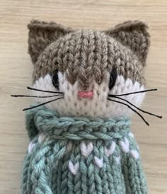 a crocheted cat wearing a green sweater