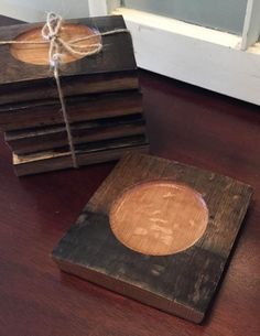 several wooden coasters tied with twine on top of a wood table in front of a door