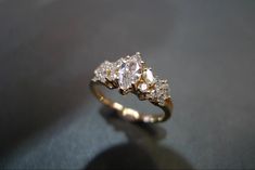 a three stone diamond ring sitting on top of a table