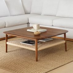 a living room with a white couch, coffee table and beige rug on the floor