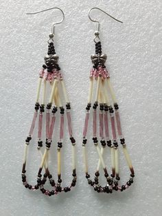 Embrace Native American culture with these stunning handmade dangle earrings featuring pale pink, black and silver beads a classic teardrop-shaped with porcupine quills. The French wire closure ensures easy wear on the earlobe, while the silver-plated metal and silver butterfly charms add a touch of elegance to your look. Ideal for any use occasion, these earrings are perfect for engagements, graduations, weddings, anniversaries, birthdays, Valentine's Day, Mother's Day, Father's Day, and Christmas. Designed by Little Beaver, a Choctaw artisan, these earrings are a unique addition to any jewelry collection. The intricate details of the beading and the tribal affiliation make them stand out from the rest. Handmade in the United States, these earrings are a must-have for those who appreciate Beaded Fringe Earrings Native American, Native Jewelry Beaded, Valentine Earrings Beaded, Beading Earrings Patterns, Beaded Hoop Earrings Native American, Porcupine Quill Jewelry, Quill Earrings, Indigenous Jewelry, Native Beaded Earrings