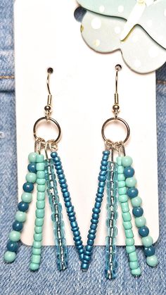 some beads are hanging from the back of a pair of earrings