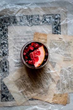 a glass filled with fruit sitting on top of a table next to papers and napkins