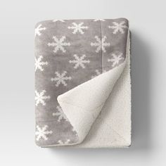 a blanket that has snowflakes on it and is folded up in front of the camera