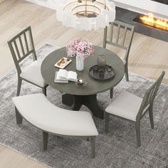 a round table with four chairs around it and a fireplace in the backround