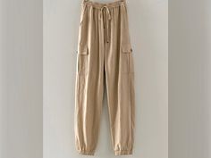 "Stay comfortable and stylish this summer with these premium quality mid rise jogger linen pants. Featuring an elastic waistband, adjustable drawstring, and cargo pockets, these pants are perfect for a beach vacation, lounge day, or resort cruise. Choose from the colors of Mint, Khaki, and White in sizes ranging from small to large. With real side pockets, you'll have a place to store your essentials while looking chic and fashionable. Upgrade your summer wardrobe with these must-have cargo line Summer Khaki Cargo Pants With Drawstring, Casual Summer Cargo Pants With Drawstring, Summer Relaxed Fit Cargo Pants With Drawstring, Summer Linen Cargo Pants With Elastic Waistband, Casual Linen Cargo Bottoms, Casual Linen Cargo Pants, Summer Comfortable Relaxed Fit Cargo Pants, Beige Linen Cargo Pants With Pockets, Summer Beige Drawstring Cargo Pants