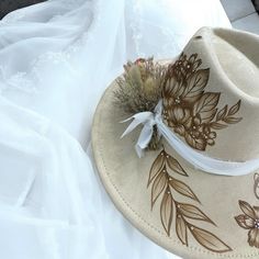 Burned Wide Brim Bridal focused Hat in Antique Beige, but also available in other shades of white. This Hat is burned using pyrography techniques. Embellishments with Rhinestones used for some bling and brightness. Dried Flowers and chiffon ribboning for the band details. Add your Date, initials and anything else youll want on your Forever Hat. Hats Boho Bridal, Dried Flowers Hat Band, Luxury White Elegant Hat Bands, Bohemian Wedding Hat With Adjustable Fit, Bohemian Adjustable Wedding Hat, Pyrography Techniques, Bridal Hats, Velvet Hat, October 5