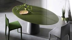 a green table with two chairs and a potted plant sitting on top of it