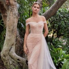 a woman in a dress standing next to a tree