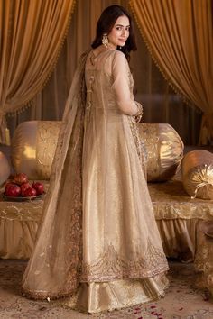 Pakistani Wedding Dress in Gold Open Gown Lehenga Style is a stunning attire that is an epitome of beauty and tradition. This stunning Pakistani Bridal Outfit is adorned with lavish designs, hand-crafted embellishments, and it comes in premium quality fabric, creating a lavish attire for the wedding. Pakistani Bridal Gown: Pakistani Bridal Gown in open style an alluring golden color and is beautifully embellished with the intricate designs and shimmering goldwork. Sequins, motifs, stones, and pe Traditional Gold Wedding Dress With Dabka Work, Floor-length Wedding Dress With Sheer Dupatta For Ceremony, Gold Wedding Dress With Dabka Work, Festive Embellished Anarkali Set For Ceremony, Embellished Floor-length Anarkali Set For Ceremony, Ceremonial Floor-length Embellished Anarkali Set, Festive Wedding Gown With Long Train, Ceremony Embellished Floor-length Anarkali Set, Traditional Anarkali Wedding Dress For Ceremony