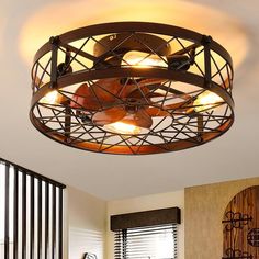 a living room with a ceiling fan and some lights in it's centerpiece