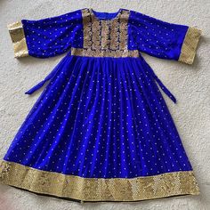 Beautiful Afghan Ethnic Traditional Blue Dress With Handmade Gold Embroidery. The Flared Sleeves And Wide Sweep Make It Perfect To Wear To Parties And Weddings! Brand New Size: Fits Medium To Large (Comes With Back Zipper And Adjustable Waist Strap And Max Waist Would Be: 40in) Add-Ons: Waist Strap, Back Zipper, And A Beautiful Blue Scarf Fabric: Chiffon Measurements (Taken Laying Flat On Ground) In Inches: Length: 54 Shoulder: 15 Sleeve: 21.5 Sweep: 55.5 Waist: 20 Floor-length Blue Kurta With Zari Work, Eid Festival Kaftan With Zari Work, Blue Floor-length Kurta With Zari Work, Blue Kaftan With Zari Work For Diwali, Anarkali Style Festival Kaftan With Traditional Drape, Blue Zari Work Kaftan For Diwali, Floor-length Blue Kurta With Mirror Work, Festival Anarkali Style Kaftan With Traditional Drape, Festive Kaftan With Pallu For Navratri