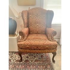 an old chair is upholstered on top of a rug