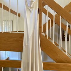 a white dress hanging from a wooden banister