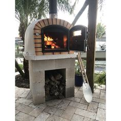 an outdoor pizza oven with wood burning in it