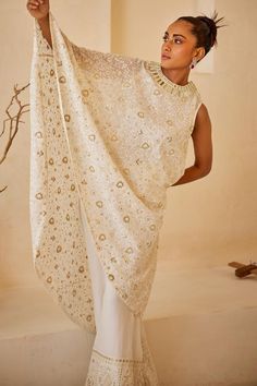 White flared asymmetric cape featuring all over chikankari embroidered floral motifs with sequin embellishments.
Components: 1
Pattern: Embroidered
Type Of Work: Chikankari,Sequin
Neckline: Round
Sleeve Type: Asymmetric
Fabric: Georgette
Color: White
Other Details: 
Flared silhouette
Note: Pant worn by the model is not for sale
Occasion: Cocktail,Sangeet - Aza Fashions Embroidered Saree With Cape Sleeves For Wedding, Wedding Saree With Embroidered Cape Sleeves, Festive Kurta With Dabka Work And Cape Sleeves, Festive Kurta With Cape Sleeves And Dabka Work, Festive Kurta With Sheer Dupatta And Cape Sleeves, Cape Sleeve Blouse With Dupatta For Diwali, Traditional Dupatta With Chikankari Embroidery And Cape Sleeves, Traditional Chikankari Embroidered Dupatta, Traditional Chikankari Embroidery Dupatta With Cape Sleeves