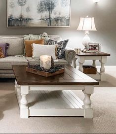 a living room filled with furniture and a painting on the wall above it's coffee table