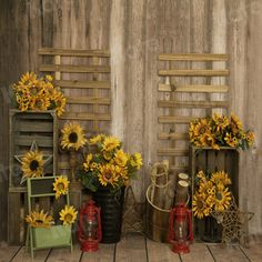 sunflowers and other flowers are displayed in front of an old wooden wall